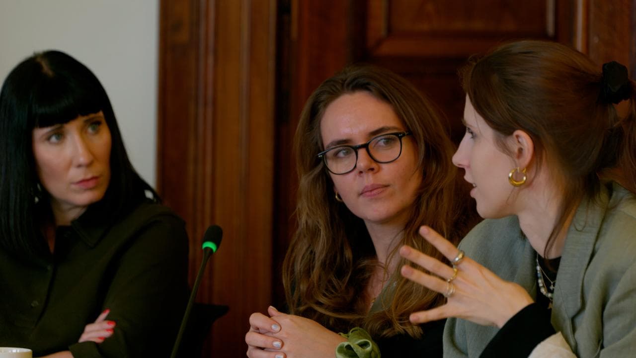 Das Bild zeigt drei Mitarbeiter:innen des Innocence Project Deutschland bei der Arbeit im Gerichtssaal.